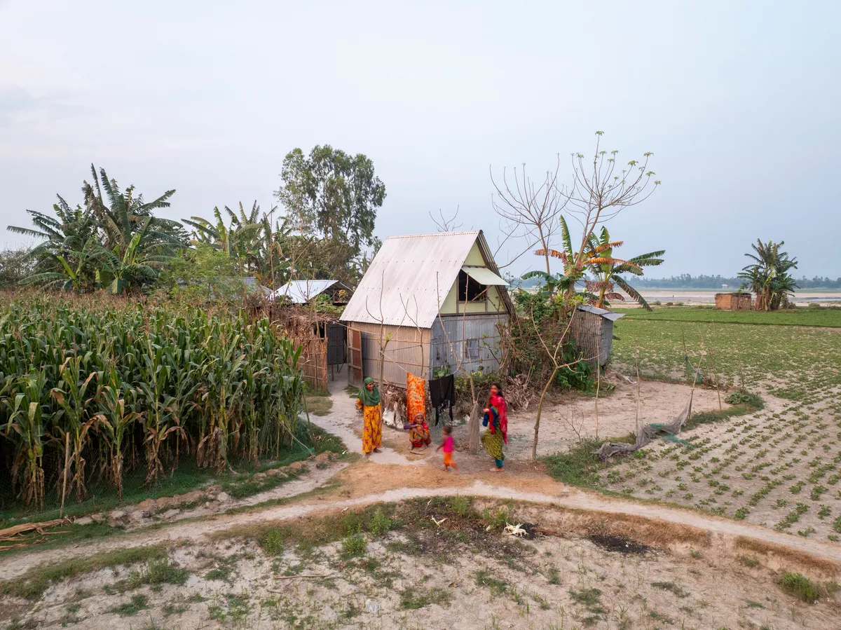 A Khudi Bari bamboo shelter erected on a char sandbar in Kurigram district, Bangladesh, with the surrounding riverine landscape